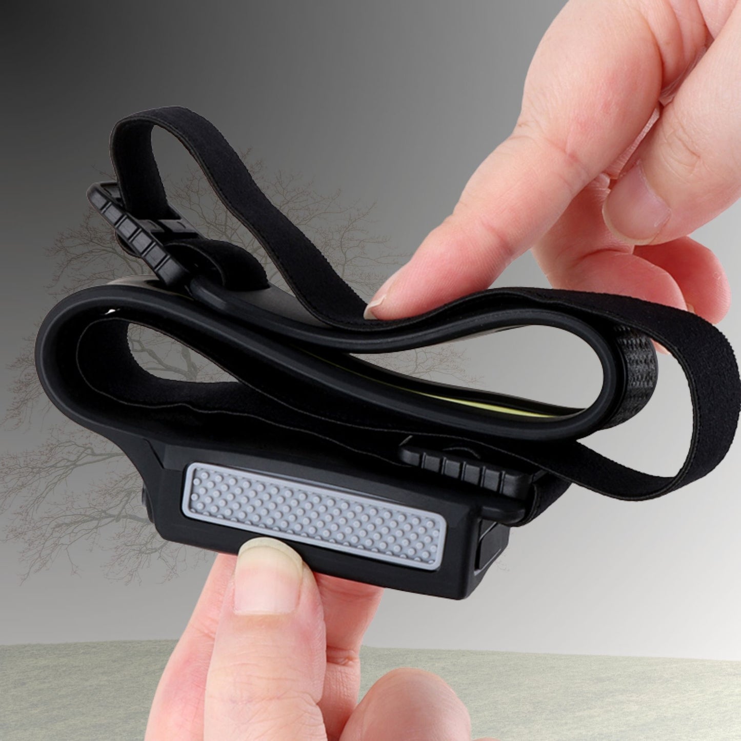 Flexible elastic headband on rechargeable head torch being bent to show comfortable fit